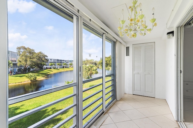 doorway to outside featuring a water view and light tile patterned floors