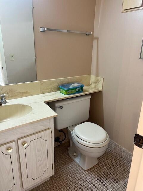 bathroom featuring vanity, tile patterned floors, and toilet