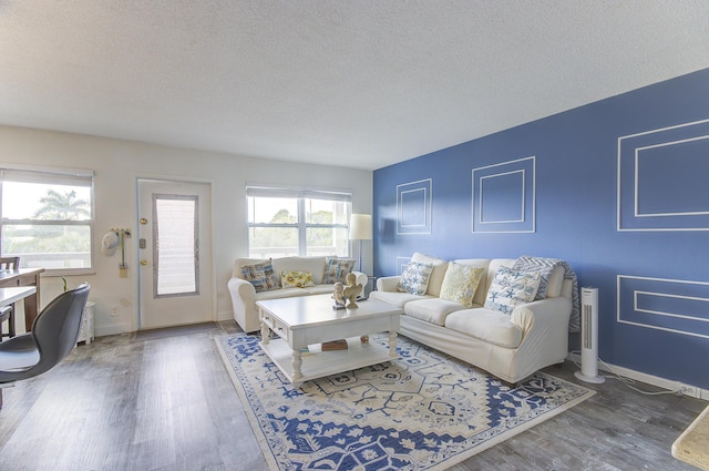 living room with dark wood-type flooring and a textured ceiling