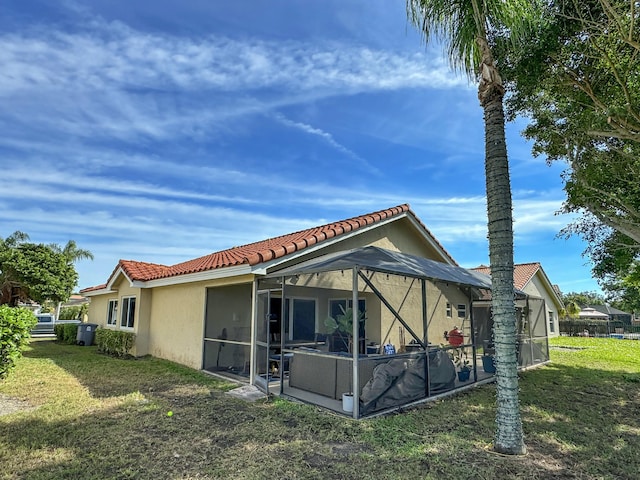 view of side of home with a yard and a lanai