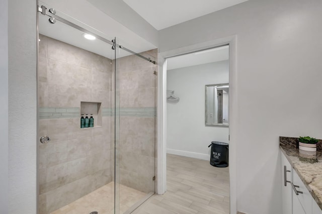 bathroom with vanity and a tile shower