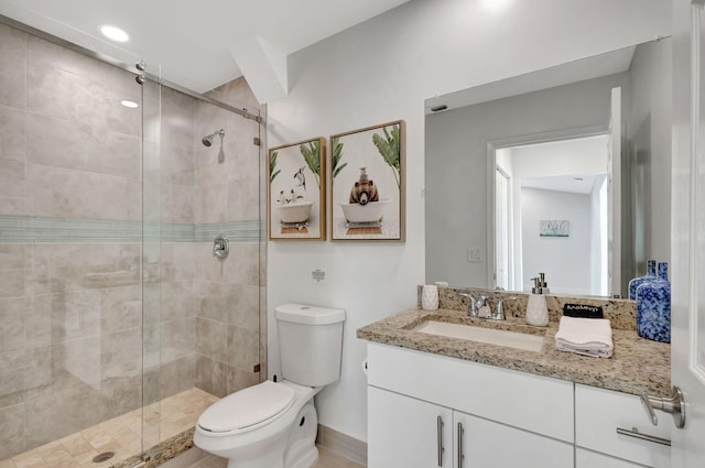 bathroom featuring vanity, toilet, and a shower with door