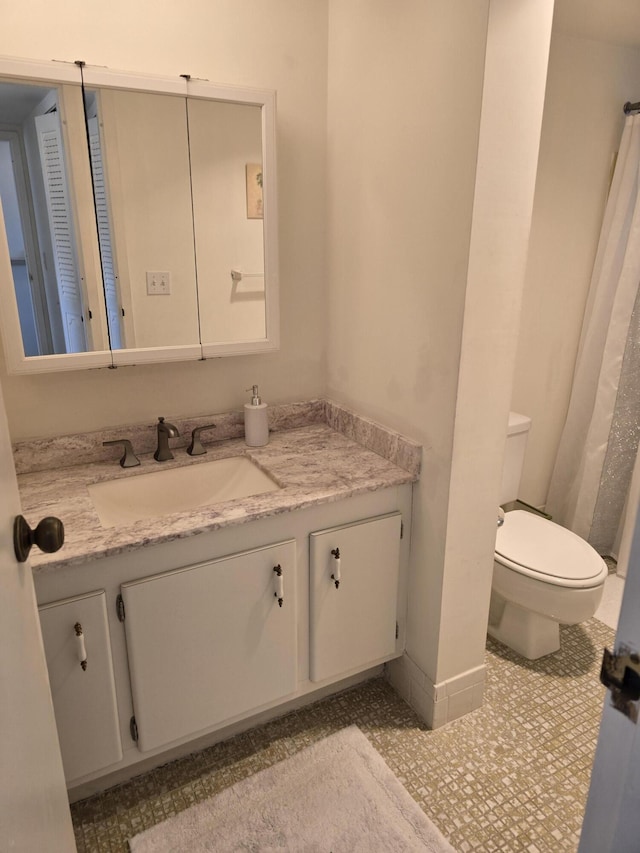 bathroom with vanity, tile patterned floors, and toilet