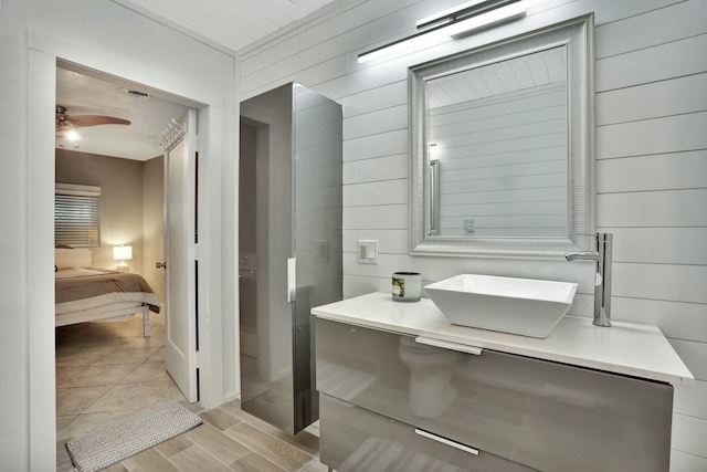 bathroom featuring sink, ceiling fan, and wood walls