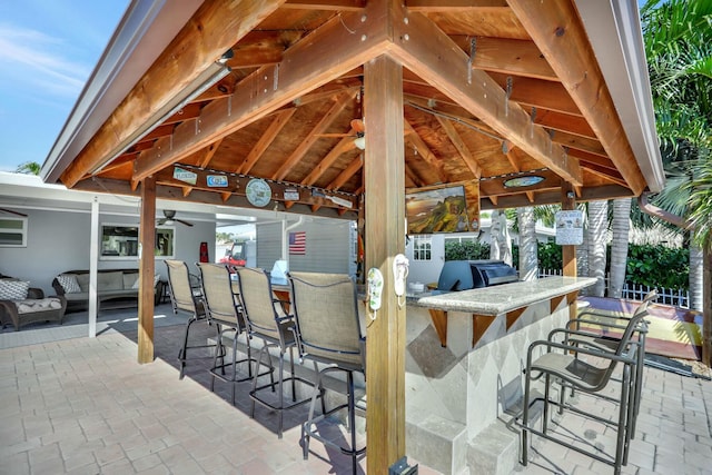 view of patio with area for grilling, a gazebo, and an outdoor bar