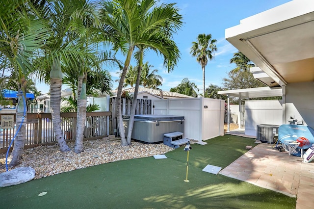 view of yard with a hot tub, central AC unit, and a patio