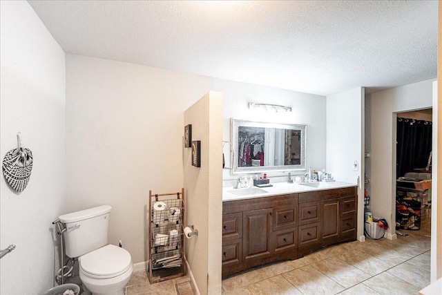 bathroom featuring tile patterned floors, vanity, toilet, and a textured ceiling