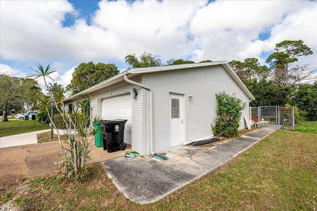 view of property exterior with a garage and a lawn