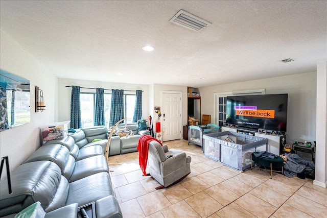 living room with a textured ceiling and light tile patterned floors