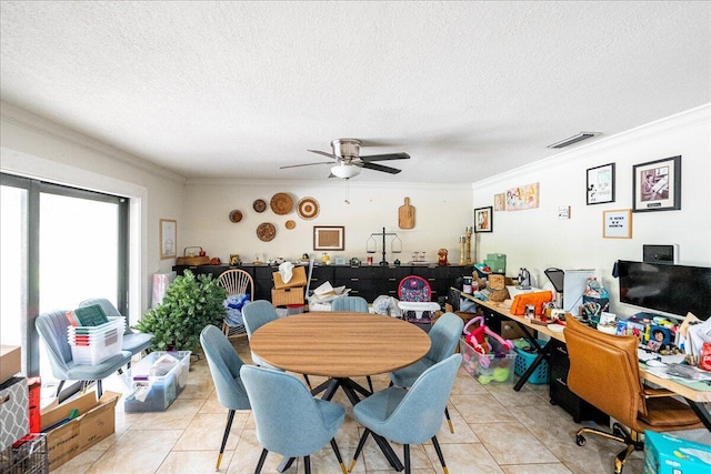 tiled dining space with ornamental molding, ceiling fan, and a textured ceiling