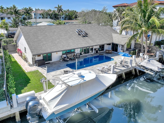 pool with a patio, a yard, a fenced backyard, and a boat dock