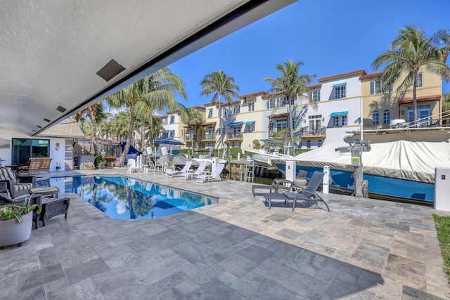 pool with a patio area and a residential view