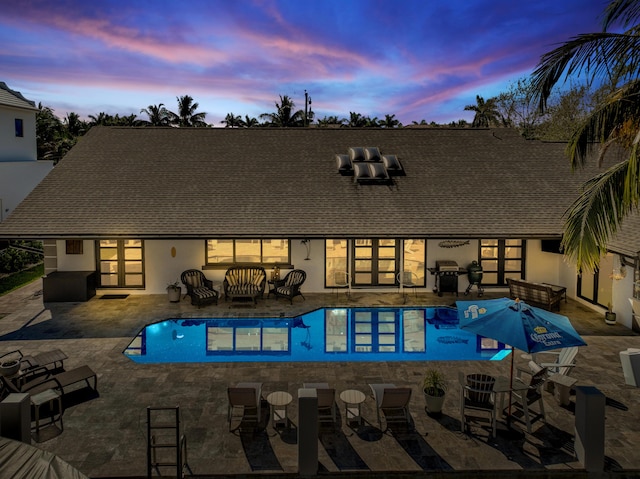 outdoor pool with a patio area and area for grilling