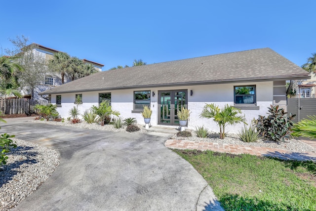 single story home with a shingled roof, french doors, and stucco siding