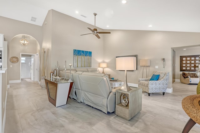 living area with arched walkways, high vaulted ceiling, ceiling fan, visible vents, and baseboards