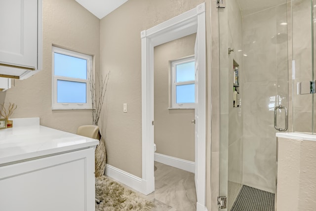 bathroom featuring toilet, a stall shower, and a wealth of natural light