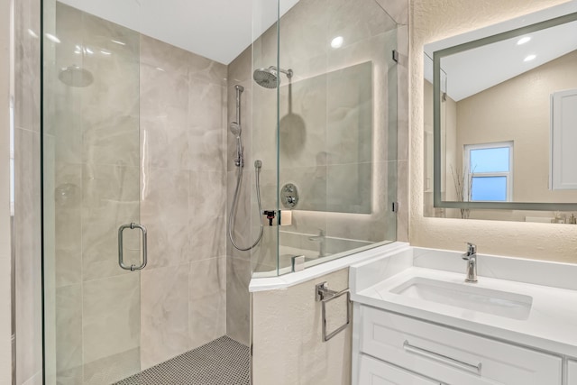 bathroom with a shower stall and vanity