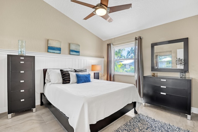 bedroom featuring lofted ceiling, ceiling fan, and a textured ceiling