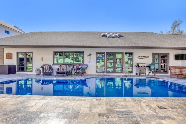 outdoor pool featuring a patio, french doors, and a grill