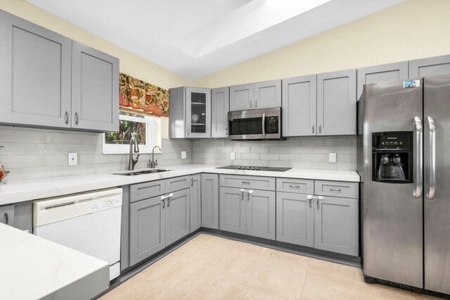 kitchen with stainless steel appliances, tasteful backsplash, gray cabinets, and light tile patterned flooring