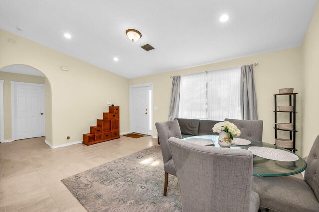 tiled living room featuring vaulted ceiling