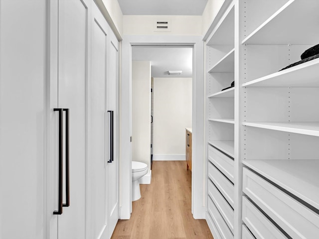 walk in closet with light wood-type flooring and visible vents