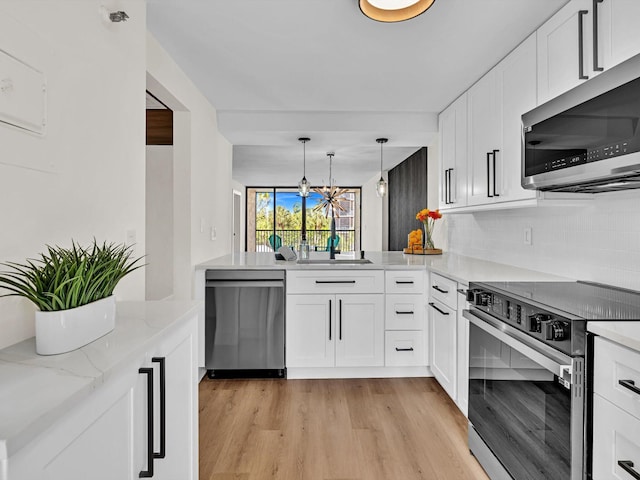 kitchen featuring sink, light hardwood / wood-style flooring, appliances with stainless steel finishes, white cabinets, and backsplash