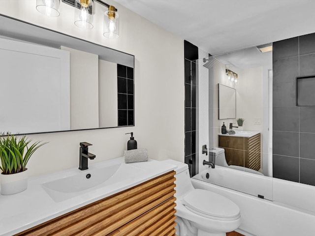 full bathroom featuring tiled shower / bath, vanity, and toilet