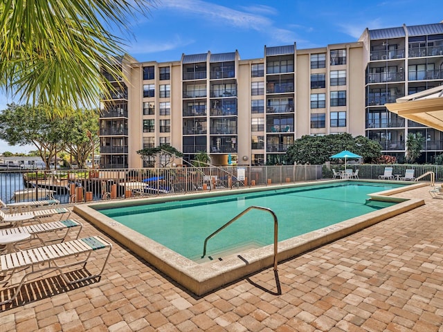 pool featuring fence and a patio