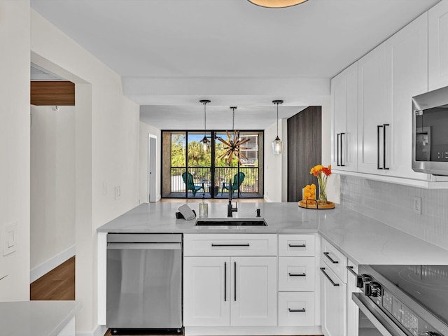 kitchen with sink, appliances with stainless steel finishes, light stone countertops, white cabinets, and decorative backsplash