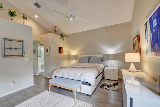 bedroom with dark wood-type flooring, lofted ceiling, and a textured ceiling