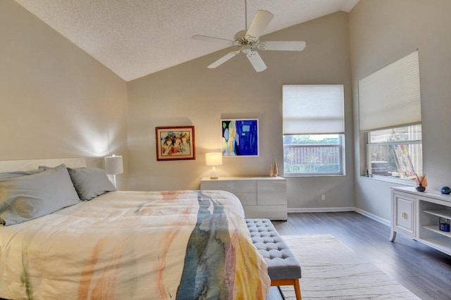 bedroom with ceiling fan, dark hardwood / wood-style flooring, vaulted ceiling, and a textured ceiling