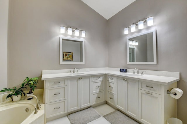 bathroom with vanity, a bath, and vaulted ceiling