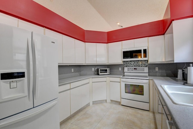 kitchen with backsplash, white cabinets, white appliances, light tile patterned floors, and a textured ceiling