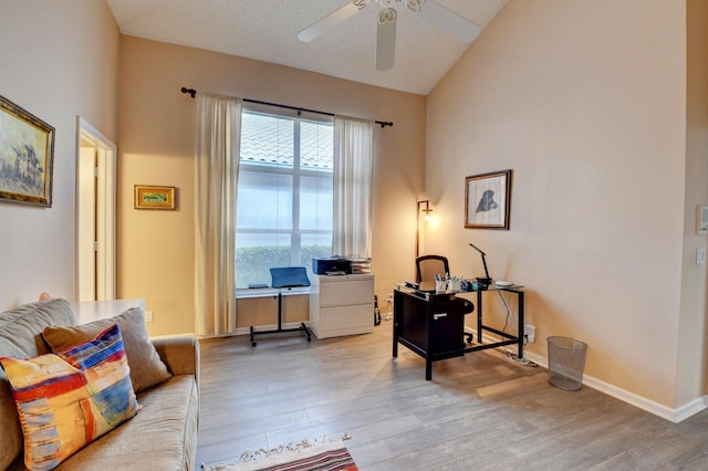 home office with vaulted ceiling, light hardwood / wood-style floors, and ceiling fan