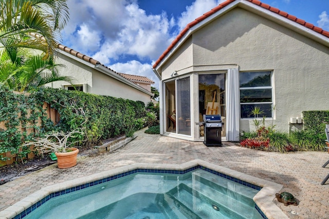 view of swimming pool with a jacuzzi and grilling area