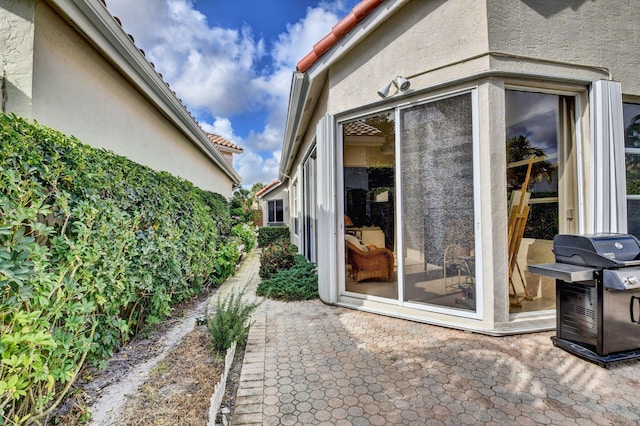 view of exterior entry with a patio