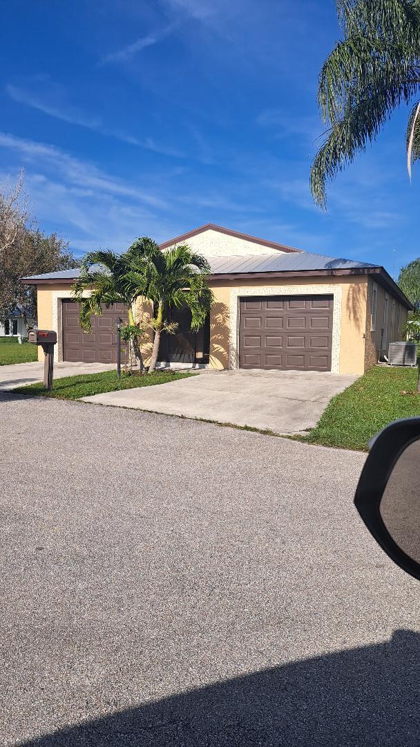 single story home featuring a garage, driveway, and stucco siding