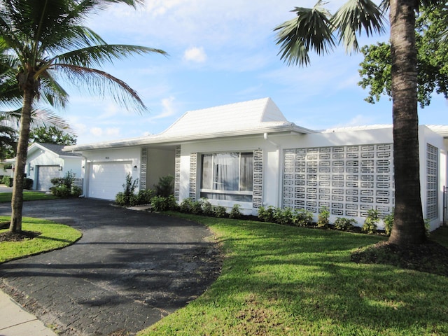 single story home featuring a garage and a front yard