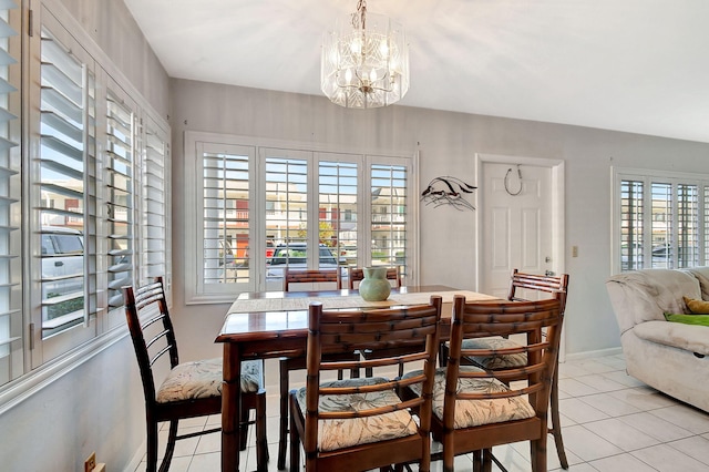 dining area featuring light tile patterned floors and an inviting chandelier