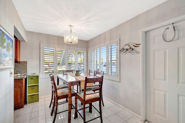 dining room with a chandelier, a healthy amount of sunlight, and light tile patterned flooring