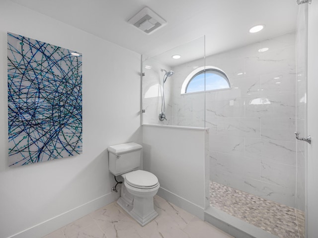 bathroom with tiled shower and toilet