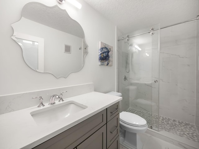 bathroom featuring vanity, a textured ceiling, toilet, and walk in shower