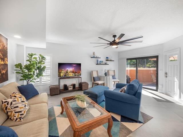 living room featuring ceiling fan, a wealth of natural light, and a textured ceiling