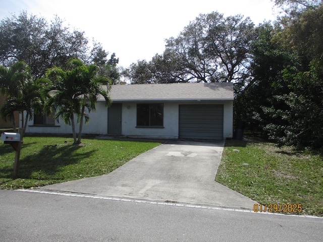 ranch-style house featuring a garage and a front lawn