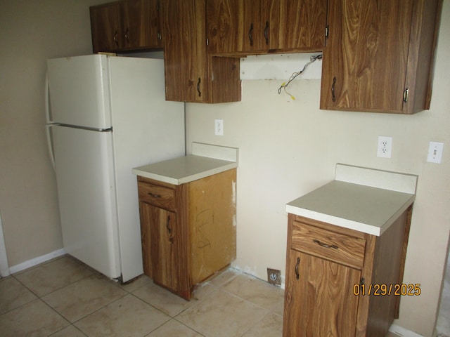 kitchen with white fridge and light tile patterned floors