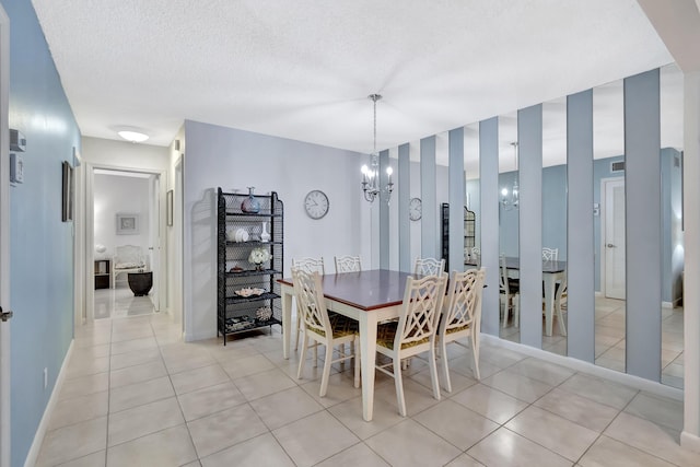 tiled dining room featuring a notable chandelier and a textured ceiling