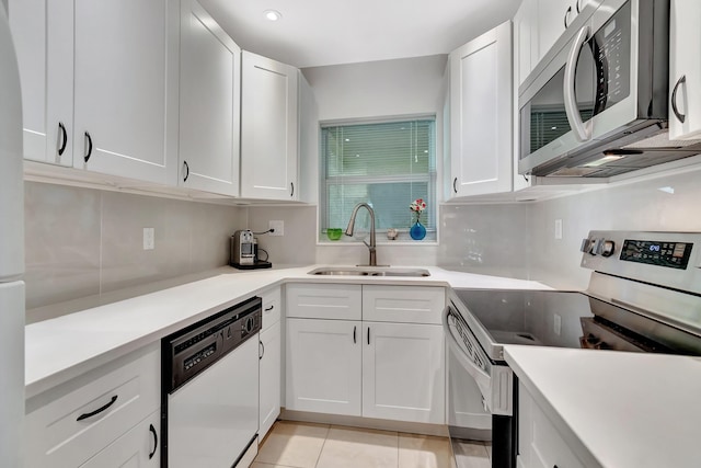 kitchen with sink, light tile patterned floors, stainless steel appliances, decorative backsplash, and white cabinets