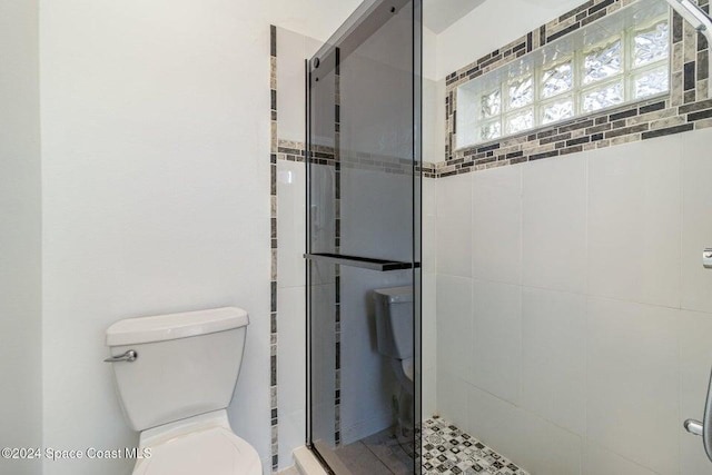 bathroom with an enclosed shower and toilet