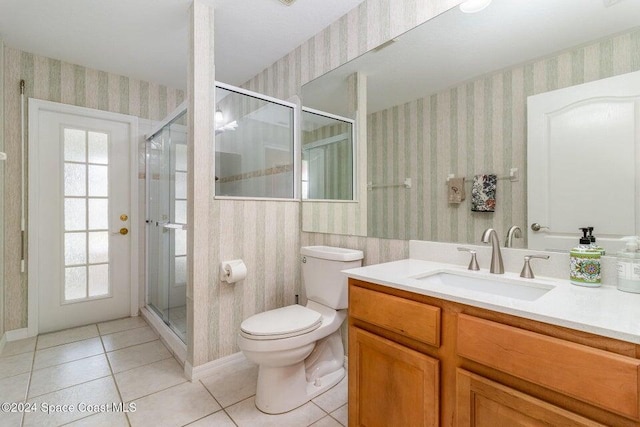 bathroom with tile patterned flooring, vanity, a healthy amount of sunlight, and toilet